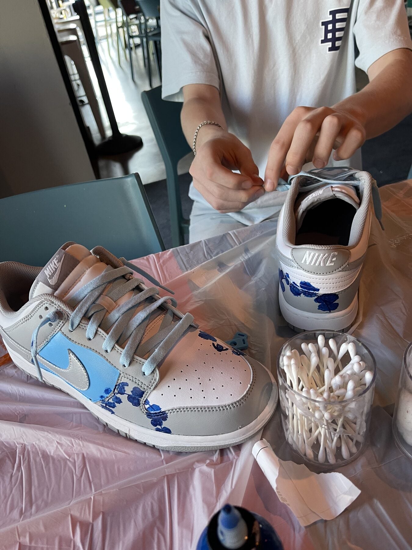 Hands painting and personalizing a Nike sneaker during a Kick Art workshop in Miami