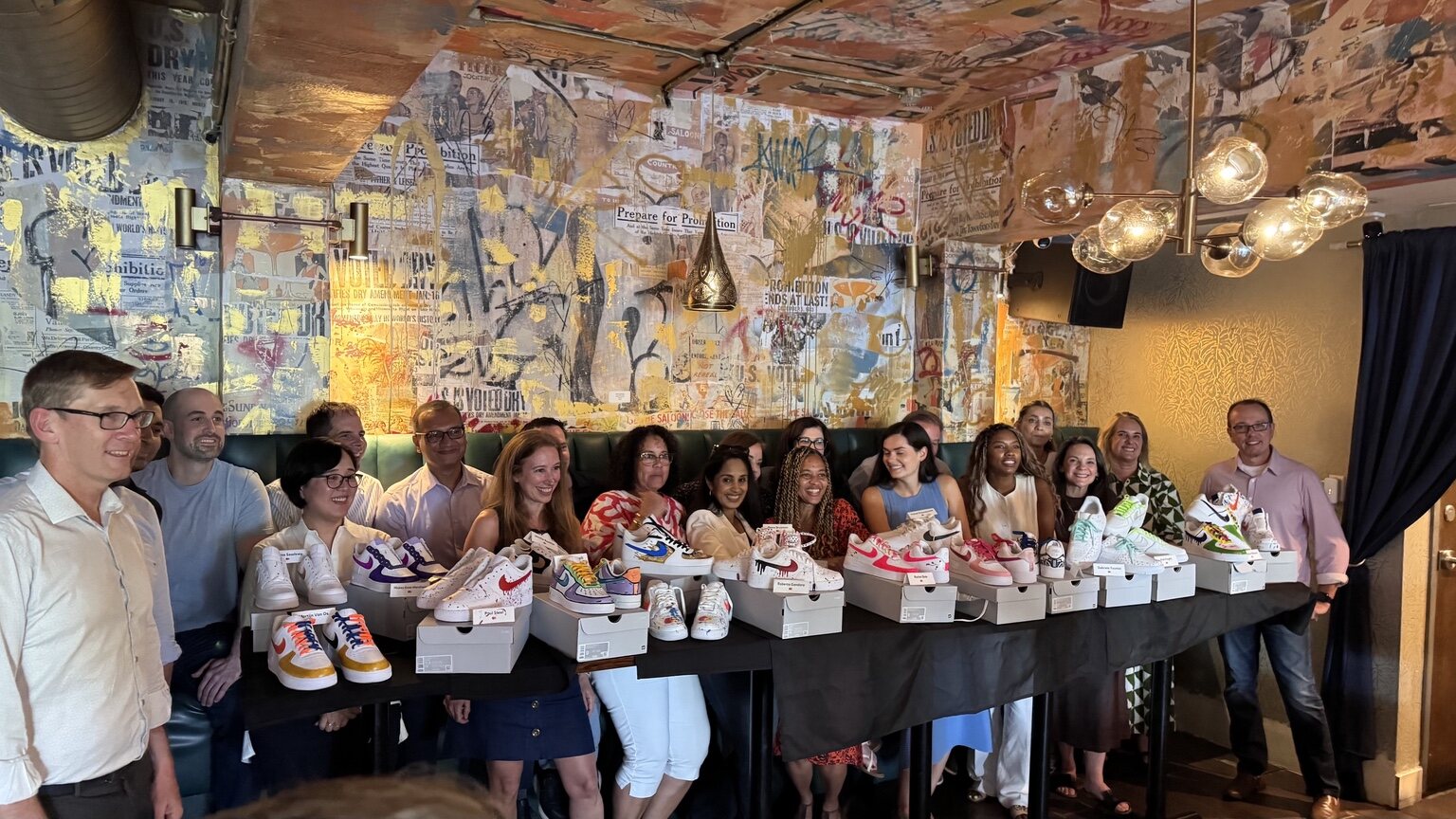 Mastercard team displaying finished custom sneakers after a Kick Art workshop at Spanglish Miami