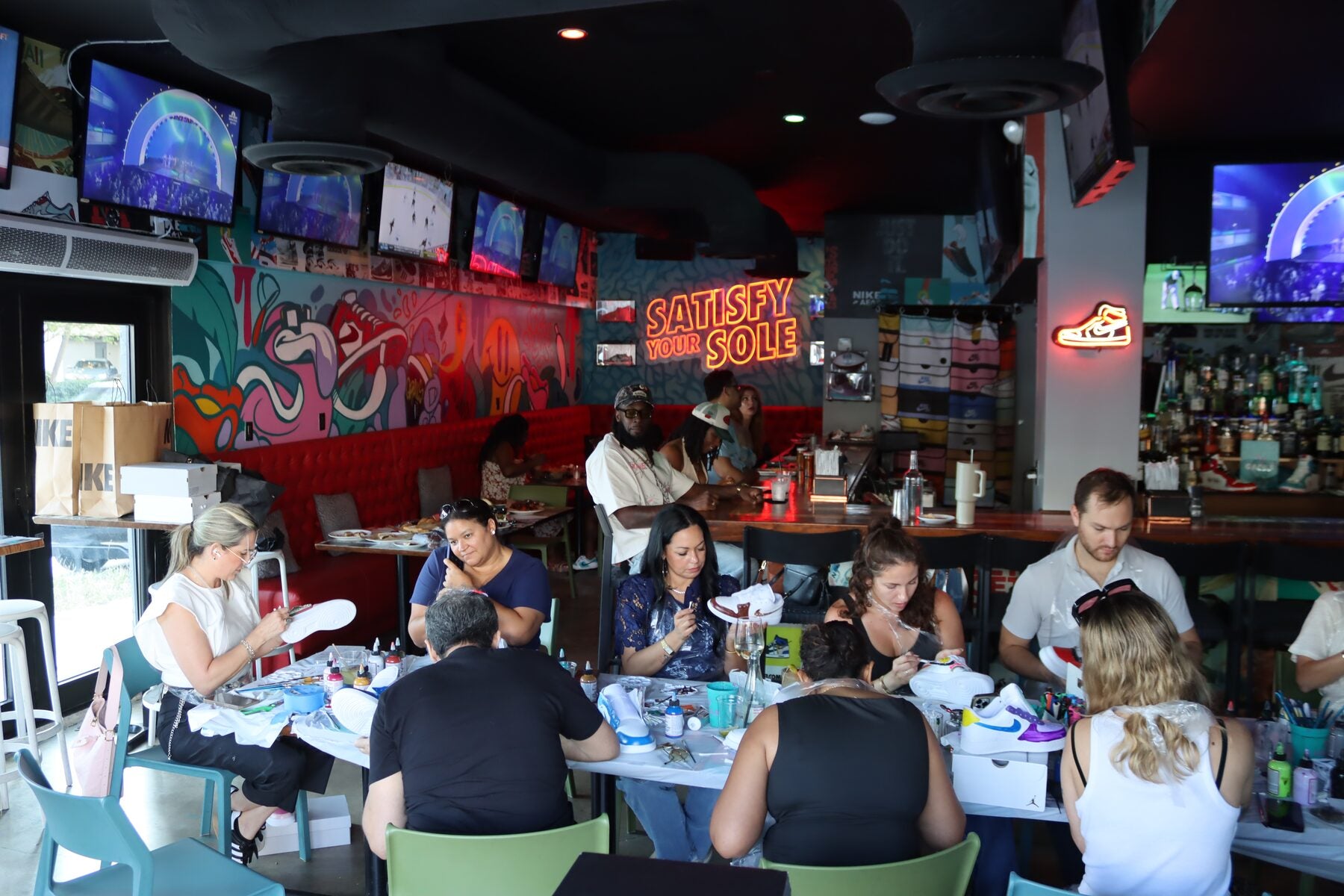 Private group customizing sneakers together at a Kick Art workshop inside Grails Miami