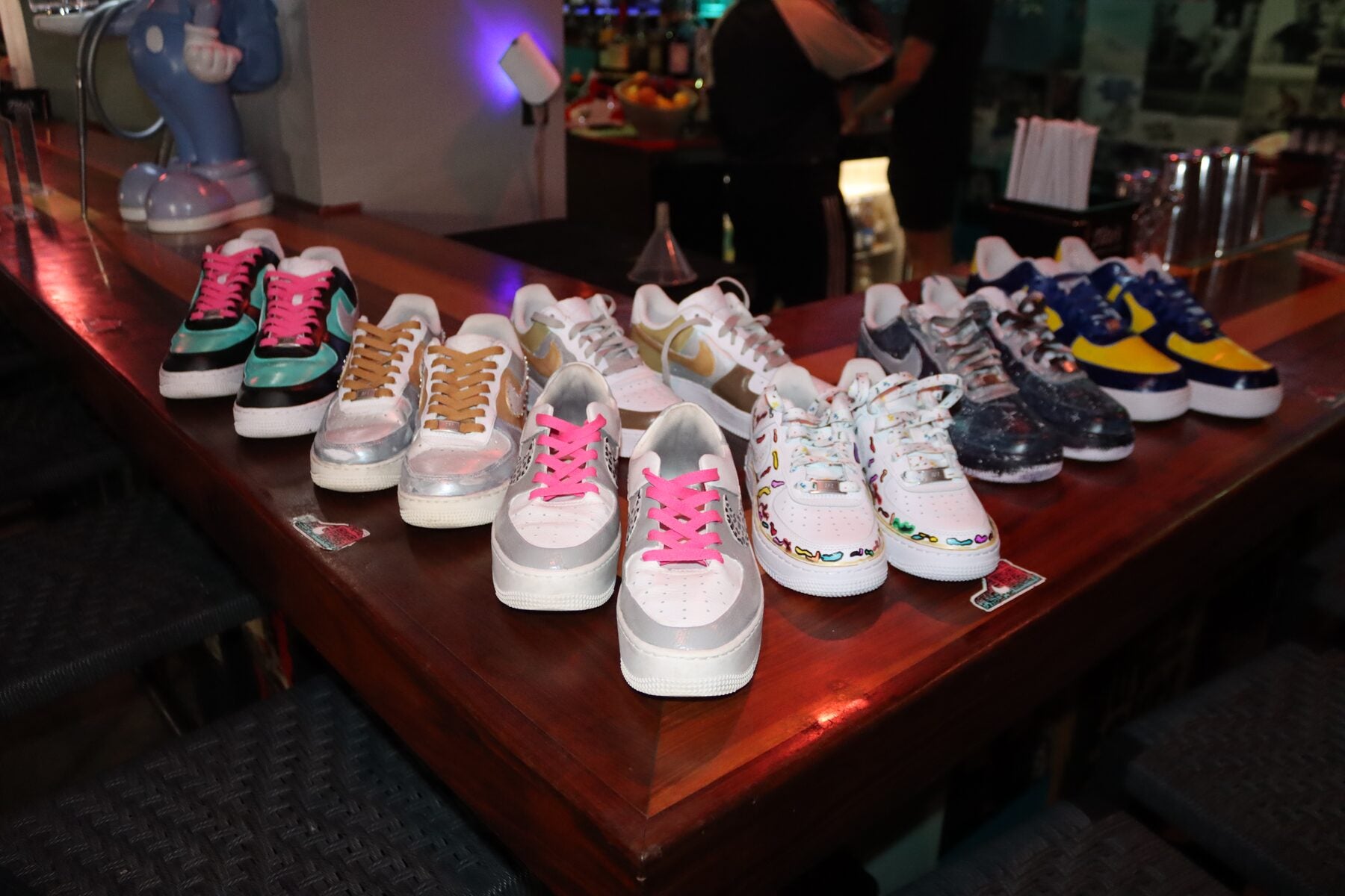 Display of finished custom sneakers created by guests at a private Kick Art party in Miami