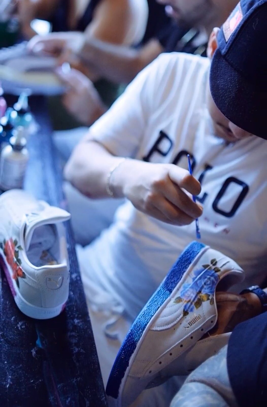 Guest painting a custom sneaker during an artist-led workshop in Wynwood Miami